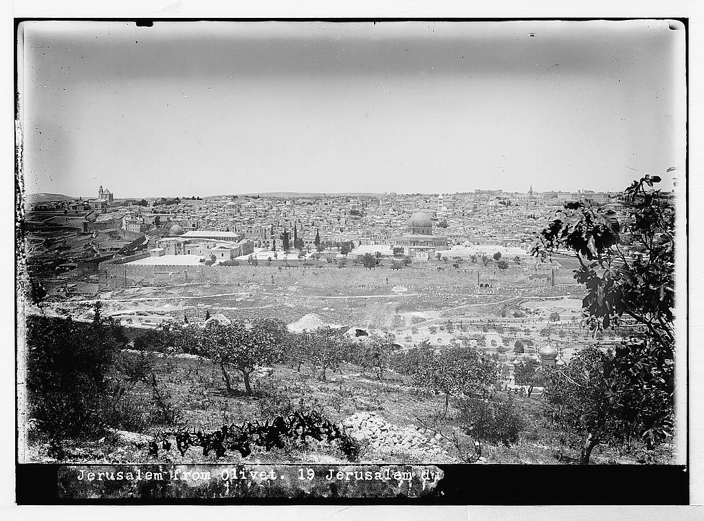 Black and white photograph of Jerusalem seen from the Mount of Olives, its stone buildings and walls spread across the hillside.