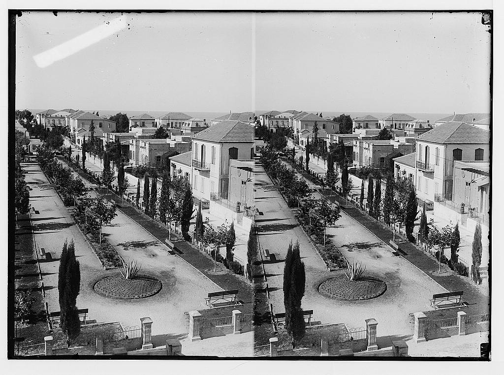 Black and white photograph of early Tel Aviv, low houses standing on open sand.